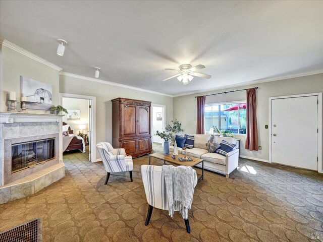living area featuring ornamental molding, a ceiling fan, visible vents, and a premium fireplace