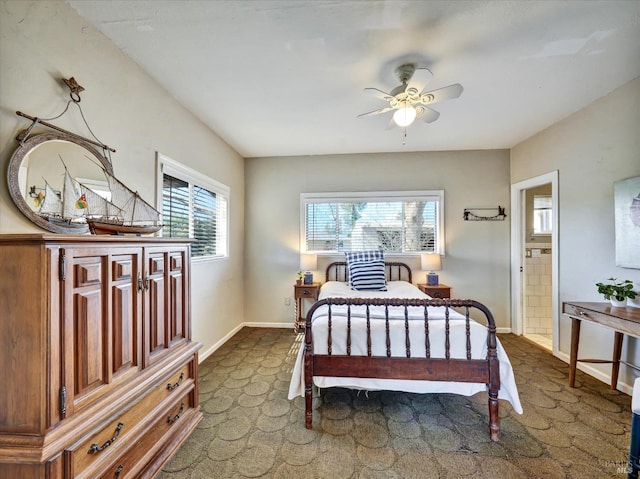 bedroom featuring ensuite bath, baseboards, and dark carpet