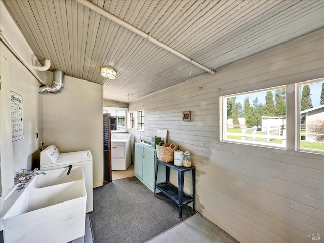 clothes washing area with a sink, laundry area, wooden ceiling, and washer and clothes dryer