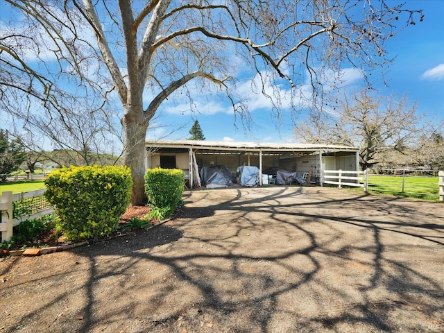 view of front facade with a carport and an outbuilding