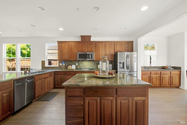 830 Elderberry Loop, Vacaville, CA 95688 - kitchen with a center island, brown cabinetry, dark stone countertops, and stainless steel appliances