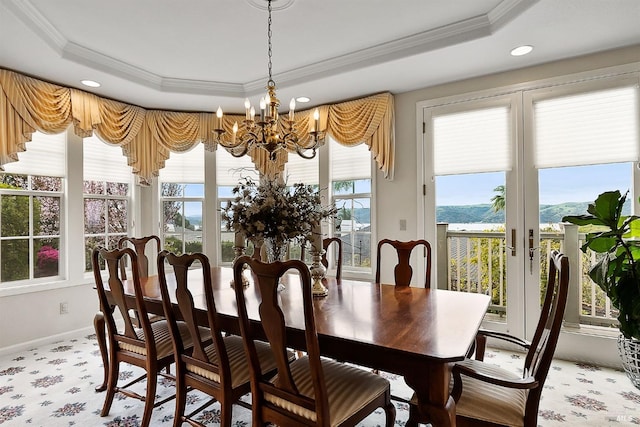dining area featuring crown molding, a notable chandelier, and a raised ceiling