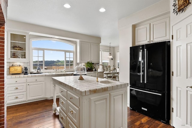 kitchen with recessed lighting, a sink, white cabinets, and freestanding refrigerator