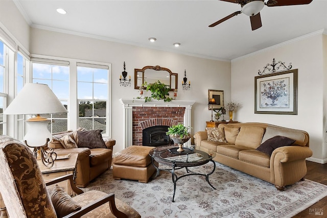 living area featuring recessed lighting, wood finished floors, ceiling fan, a fireplace, and crown molding