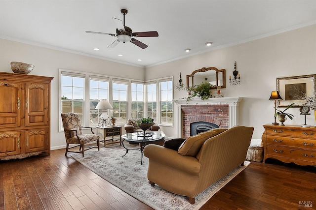 living room featuring recessed lighting, ornamental molding, dark wood-style flooring, a fireplace, and a ceiling fan