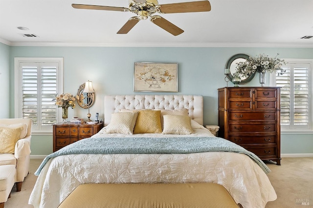 carpeted bedroom with visible vents, crown molding, a ceiling fan, and baseboards