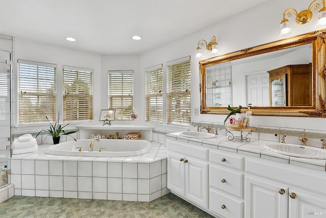 full bath with tile patterned flooring, a bath, double vanity, and a sink