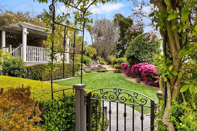 view of yard featuring a gate, fence, and a pergola