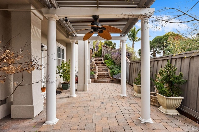 view of patio / terrace featuring ceiling fan, stairway, and fence