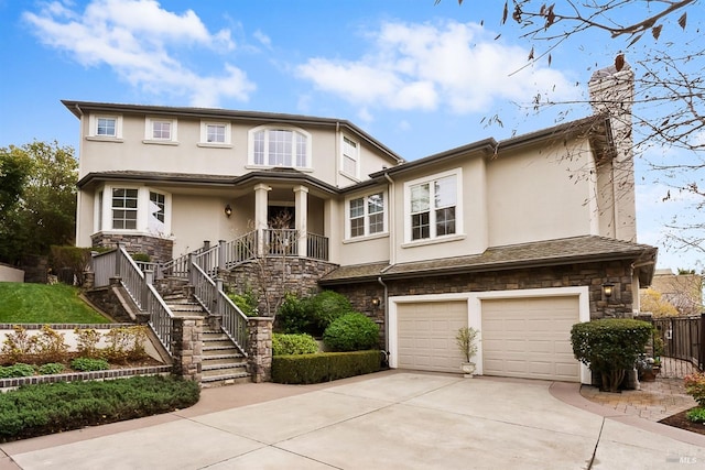 view of front of property featuring driveway, stone siding, and stucco siding