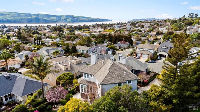 drone / aerial view featuring a residential view and a water and mountain view