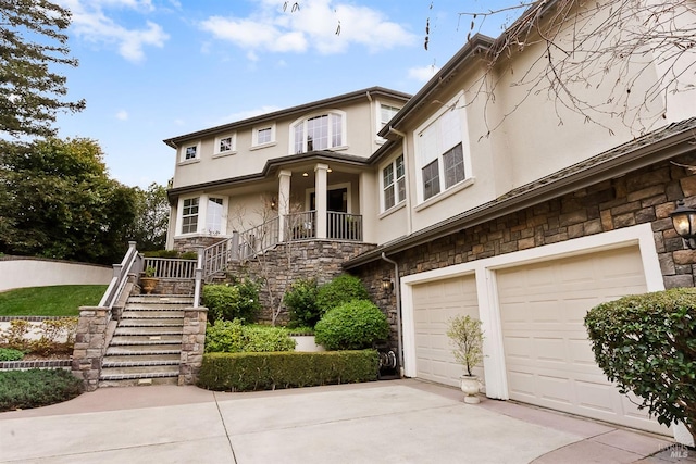 view of front facade featuring driveway, stone siding, stucco siding, stairway, and a garage
