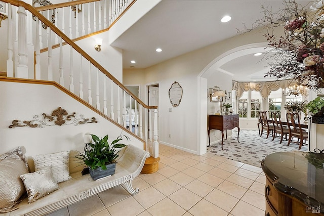 foyer entrance with tile patterned floors, recessed lighting, arched walkways, and stairs