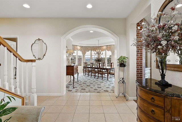 entryway featuring recessed lighting, arched walkways, stairs, light tile patterned floors, and baseboards