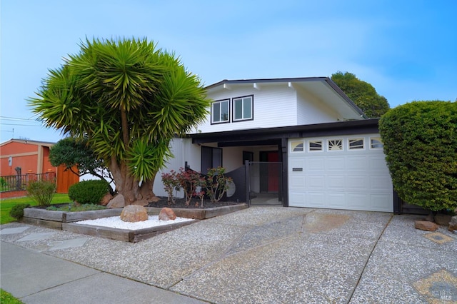 view of front of house featuring a garage, driveway, and fence