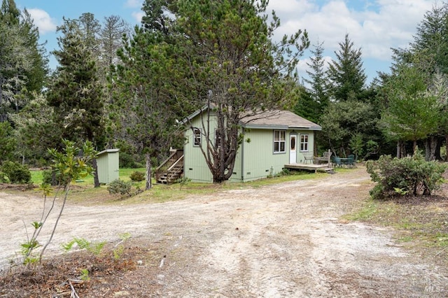 27821 Ten Mile Rd, Point Arena, CA 95468 - view of side of property featuring an outdoor structure, a wooden deck, driveway, and a storage unit