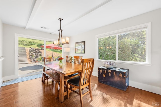 dining space featuring plenty of natural light, hardwood / wood-style flooring, visible vents, and an inviting chandelier