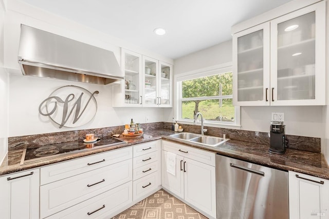 kitchen with wall chimney range hood, a sink, dishwasher, black electric stovetop, and white cabinetry
