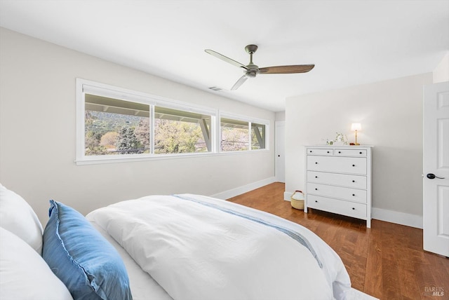 bedroom featuring wood finished floors, visible vents, baseboards, and ceiling fan
