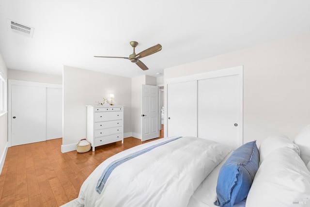 bedroom with baseboards, wood finished floors, visible vents, and a ceiling fan
