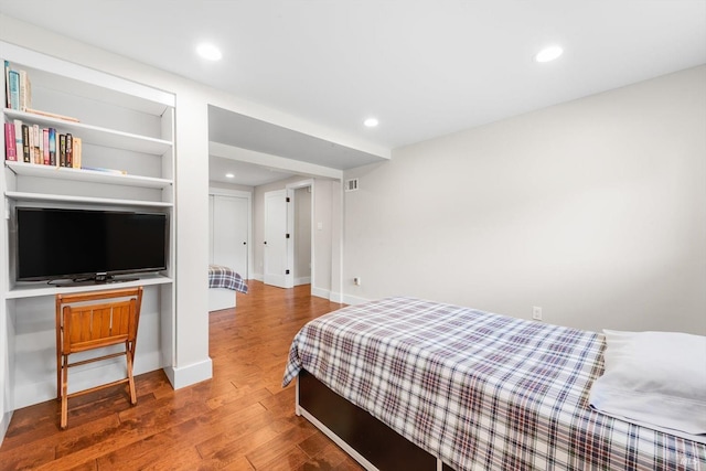 bedroom with recessed lighting, wood finished floors, and baseboards