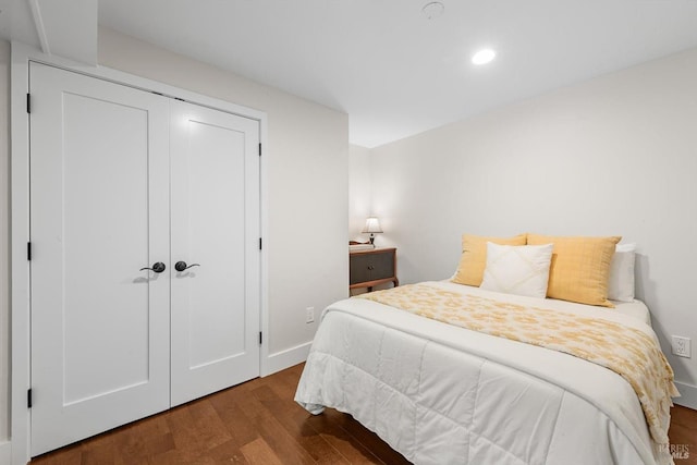 bedroom featuring baseboards, wood finished floors, recessed lighting, and a closet