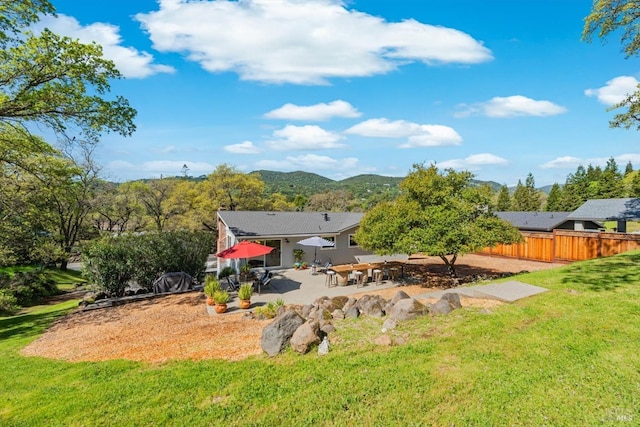 view of yard featuring a patio area, fence, and a mountain view