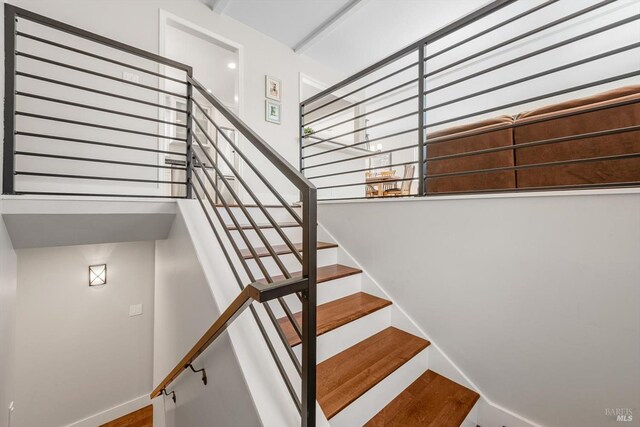 stairway featuring baseboards and wood finished floors