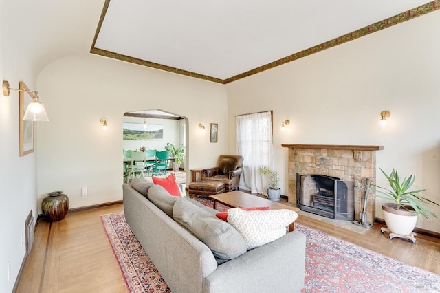 36 Wilson Ave, Vallejo, CA 94590 - living room with visible vents, light wood-style flooring, arched walkways, baseboards, and a fireplace with flush hearth