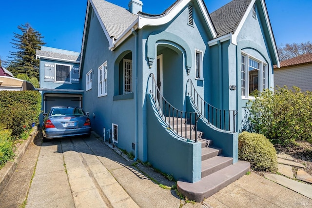 36 Wilson Ave, Vallejo, CA 94590 - view of front facade featuring a shingled roof, stucco siding, a chimney, and driveway