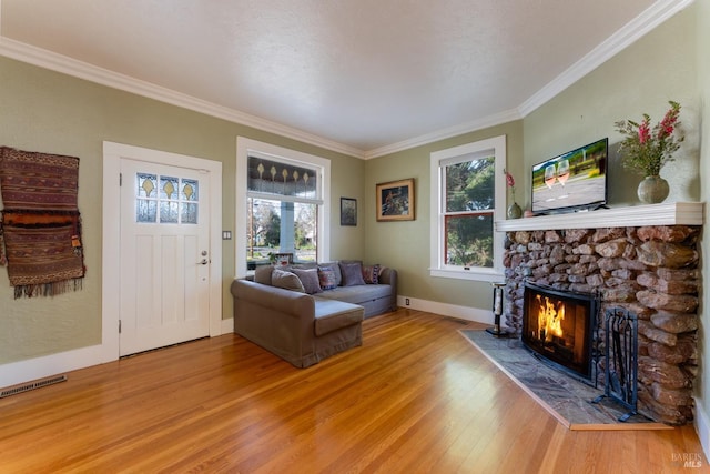 701 W Clay St, Ukiah, CA 95482 - living room with a stone fireplace, crown molding, a healthy amount of sunlight, and light wood-type flooring