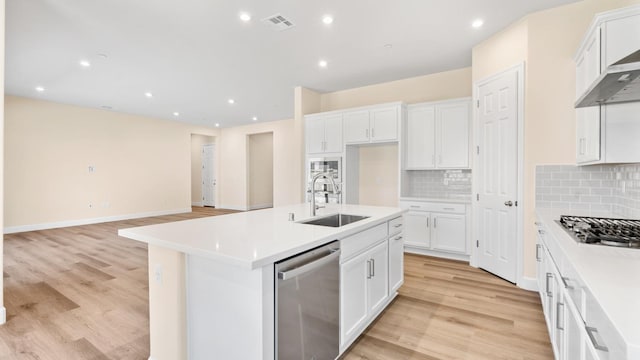 kitchen with white cabinets, a sink, stainless steel appliances, decorative backsplash, and visible vents