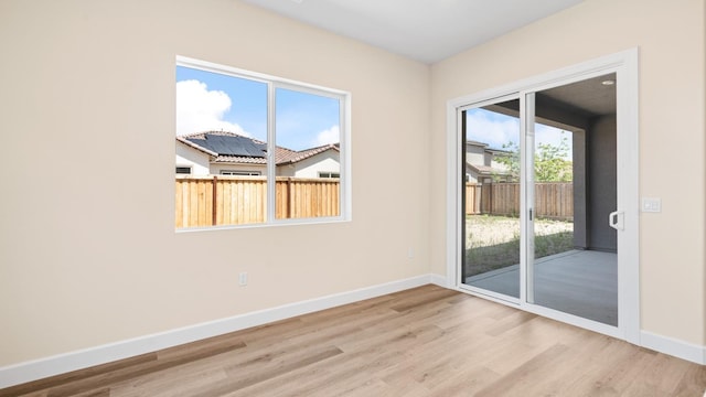 empty room with baseboards and wood finished floors