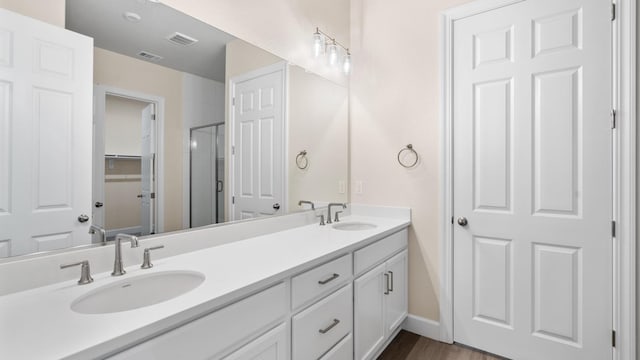 bathroom featuring double vanity, visible vents, and a sink