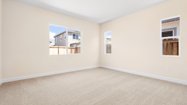 spare room featuring baseboards and carpet