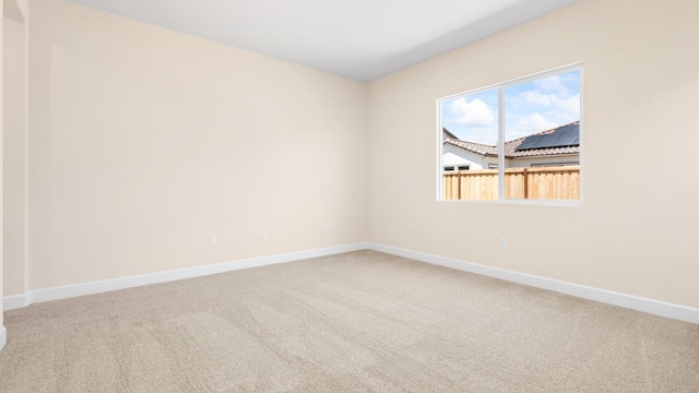 empty room featuring baseboards and carpet