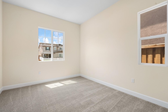 carpeted empty room featuring baseboards