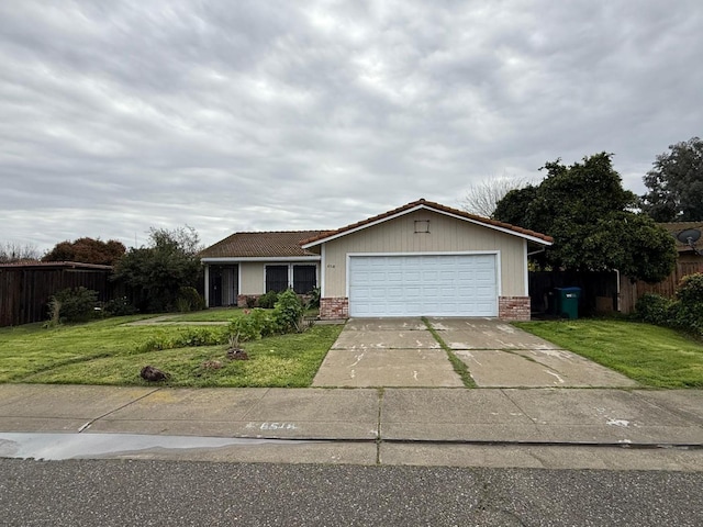 ranch-style home featuring a front lawn, fence, and a garage