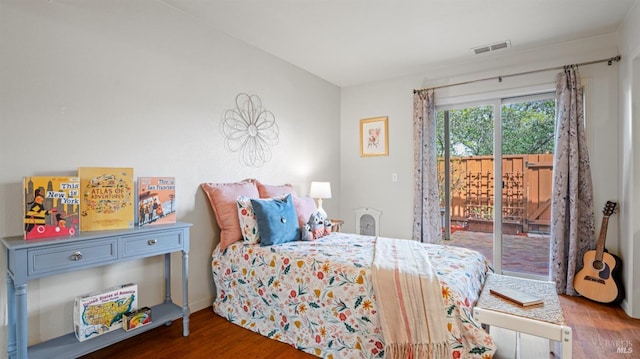 bedroom featuring access to outside, wood finished floors, and visible vents