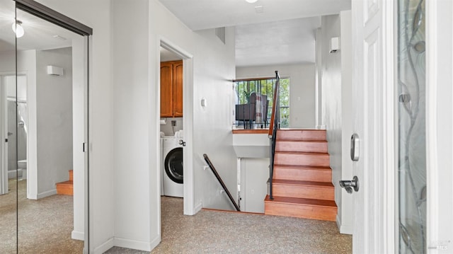 staircase featuring baseboards, washer / clothes dryer, and speckled floor
