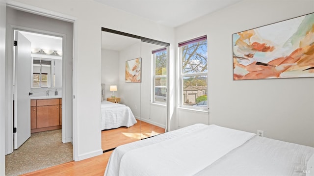 bedroom featuring a closet, baseboards, and light wood finished floors