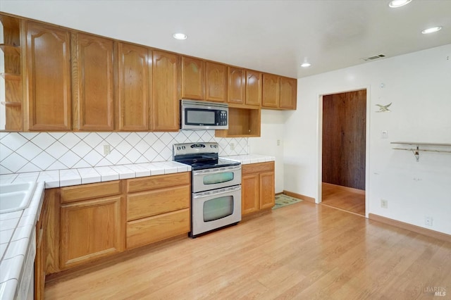 1014 Falcon Dr, Vallejo, CA 94589 - kitchen featuring visible vents, tile countertops, appliances with stainless steel finishes, and light wood-style flooring