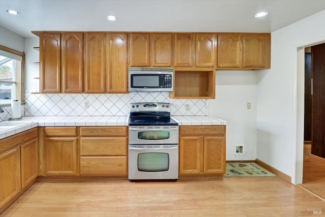 1014 Falcon Dr, Vallejo, CA 94589 - kitchen featuring tile countertops, appliances with stainless steel finishes, light wood-style floors, and open shelves