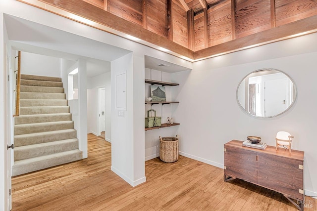 interior space featuring baseboards, stairs, and wood finished floors