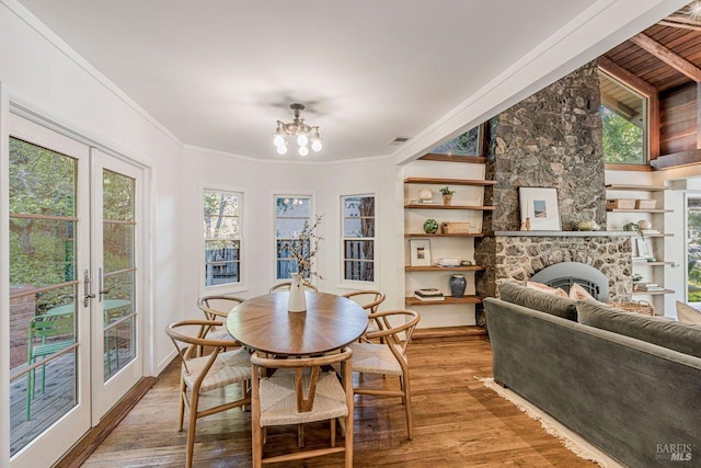 dining area with an inviting chandelier, french doors, crown molding, visible vents, and light wood-style floors