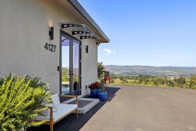 exterior space with a mountain view and stucco siding