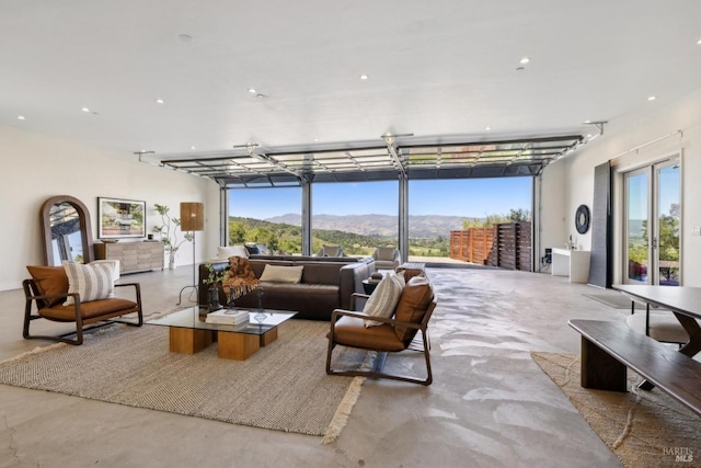 living room with recessed lighting, a mountain view, and finished concrete floors