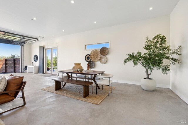dining room featuring baseboards, recessed lighting, and concrete floors