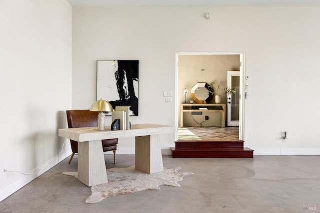 office area featuring concrete flooring and baseboards