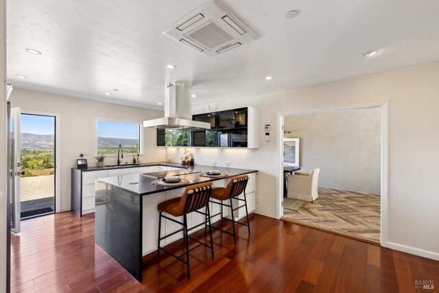 4127 Dry Creek Rd, Napa, CA 94558 - kitchen with island exhaust hood, a sink, dark countertops, dark wood finished floors, and recessed lighting